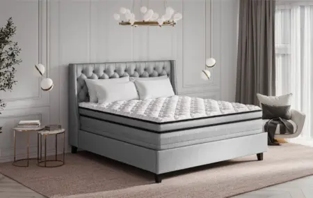 Luxury modern bedroom with grey upholstered bed, white bedding, elegant pendant lighting, and natural light, showcasing quality sleep environment, mattress, and bedroom design for comfort and style.