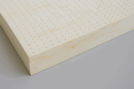 Close-up of organic Dunlop latex layers showing natural cosmetic imperfections like marbling, ridge lines, and small air bubbles.