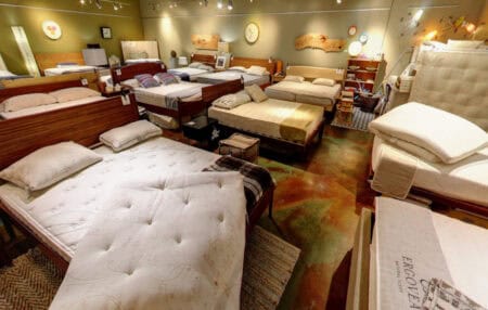 A wide selection of mattresses and beds in  Plank & Coil's retail store, showcasing different styles and firmness levels to help customers find the perfect sleep surface.